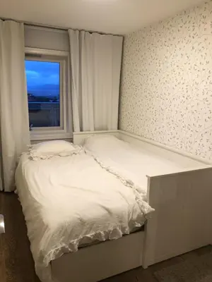 a white bed in a room with a window at Unique City Center 3-rooms panoramic view with free parking in Trondheim