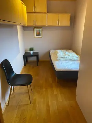 a small bedroom with a bed and a chair at Large single-family home for rent World Cup 2025 in Trondheim
