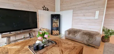 a living room with a flat screen tv and a couch at Panorama Cabin - Stunning Mountain Views and Outdoor Jacuzzi Option in Bjorli