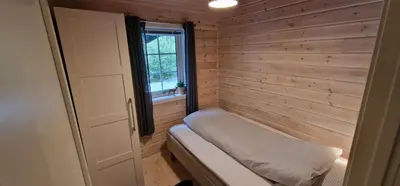 a sauna with a bench in a room with a window at Panorama Cabin - Stunning Mountain Views and Outdoor Jacuzzi Option in Bjorli