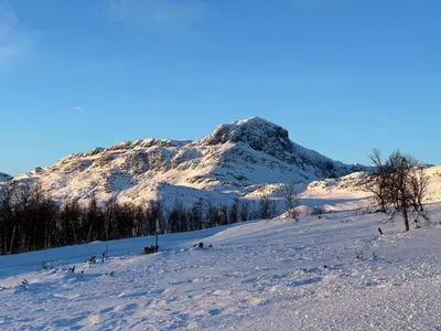 a snow covered hill with a mountain in the background at Perfectly Located-Close To Ski Slopes And Hiking Trails in Beitostøl