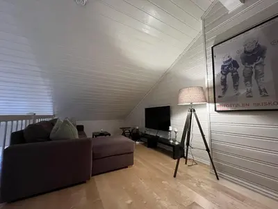 a living room with a couch and a flat screen tv at Stylish 4-Bedroom Apartment With Mountain Views! in Beitostøl