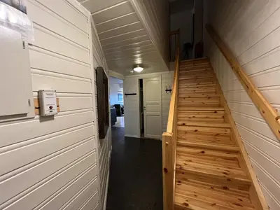 a hallway with a wooden staircase in a house at Stylish 4-Bedroom Apartment With Mountain Views! in Beitostøl