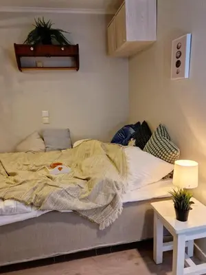 a bed with a blanket on it in a room at Sleep well in Heart of Bergen - Beautiful street in Bergen