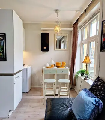 a living room with a kitchen with a table at Sleep well in Heart of Bergen - Beautiful street in Bergen