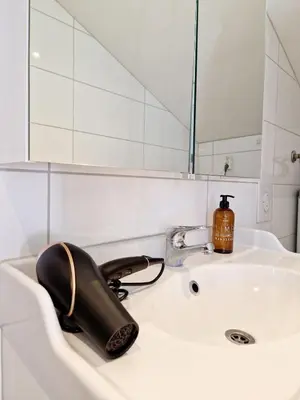 a bathroom sink with a phone and a mirror at City center Terrace in quiet backyard - Stylish in Bergen