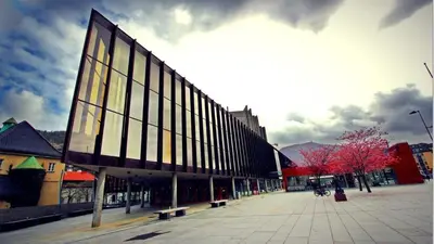 a large building on a city street with benches at City center Terrace in quiet backyard - Stylish in Bergen
