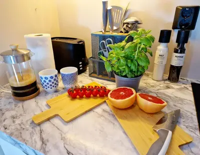 a counter with a cutting board with fruits and vegetables at Sleep well in Cozy hideout - Bryggen across the bay in Bergen
