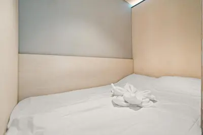 a white flower sitting on top of a bed at The Double Date I Architectural Gem in Bergen