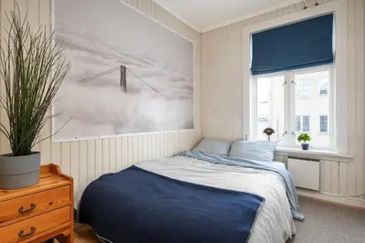 a bedroom with a bed and a painting on the wall at Cozy downtown apartment in Trondheim