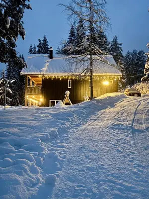 a house in the snow with lights on it at Holiday Cabin with Hot Tub and Billiard Table in Tyndrom