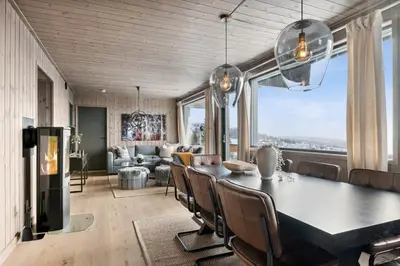 a dining room and living room with a table and chairs at Hafjell Front 220B 8pers Ski InOut, Downhill bike in Hunder