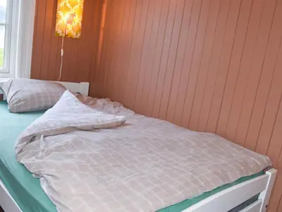 an unmade bed in a room with a wall at 6 person holiday home in Fjørtoft in Fjørtoft