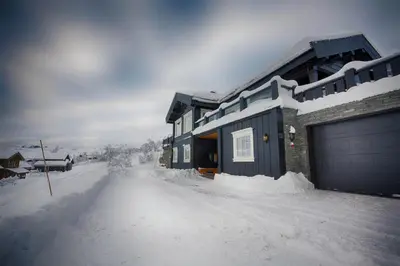 a house covered in snow with a garage at Luxury And Comfort With Stunning Views in Beitostøl
