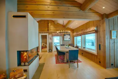 a dining room with a fireplace and a dining table at Luxury And Comfort With Stunning Views in Beitostøl
