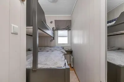 a small bedroom with two beds and a window at Utsiktsleilighet med ski in out på Hafjell 7 sengeplasser in Hunder
