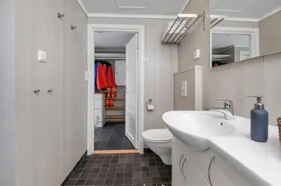 a bathroom with a white sink and a toilet at Utsiktsleilighet med ski in out på Hafjell 7 sengeplasser in Hunder