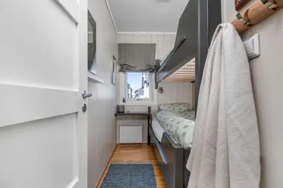 a small bedroom with a bed and a window at Utsiktsleilighet med ski in out på Hafjell 7 sengeplasser in Hunder