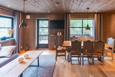a dining room with a wooden table and chairs at Trysiltunet 6A in Trysil