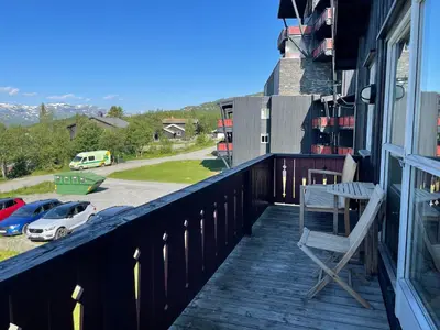 a chair on a balcony with a view of a parking lot at Family-Friendly Retreat With Fireplace And Balcony in Beitostøl