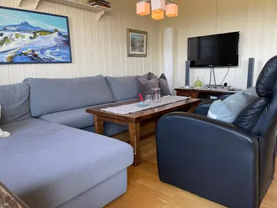 a living room with a couch and a table at Family-Friendly Retreat With Fireplace And Balcony in Beitostøl