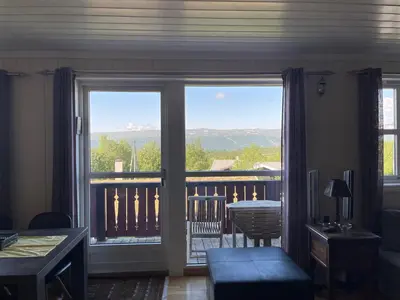 a living room with a view of a balcony at Family-Friendly Retreat With Fireplace And Balcony in Beitostøl