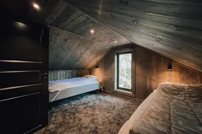 a bedroom with two beds in a wooden cabin at Modern Mountain Cabin - Outdoor Hot Tub - 8 Beds in Torpo