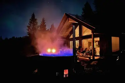 a house with a fire pit in front of it at night at Modern Mountain Cabin - Outdoor Hot Tub - 8 Beds in Torpo