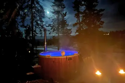 a hot tub with blue lights in a yard at night at Modern Mountain Cabin - Outdoor Hot Tub - 8 Beds in Torpo