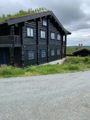 a wooden building with windows on the side of a road at Family-Friendly 2-Bedroom With Terrace And Sauna in Beitostøl