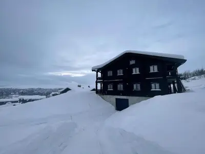 a snow covered house with a pile of snow at Family-Friendly 2-Bedroom With Terrace And Sauna in Beitostøl