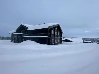 a building covered in snow in a field at Family-Friendly 2-Bedroom With Terrace And Sauna in Beitostøl