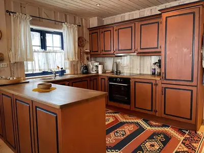 a kitchen with wooden cabinets and a counter top at Family-Friendly 2-Bedroom With Terrace And Sauna in Beitostøl