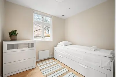a white bedroom with a bed and a window at Marken Townhouse NEW 2025 in Bergen