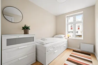 a white bedroom with a bed and a mirror at Marken Townhouse NEW 2025 in Bergen