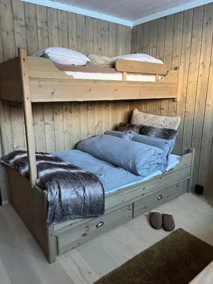 a bedroom with two bunk beds in a wooden wall at UNIQUE, Central Apartment at Geilo in Hol