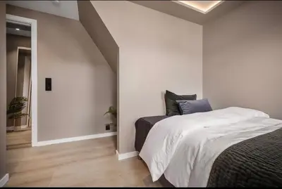 a white bedroom with a bed and a hallway at Central 2 story modern apartment in Bergen