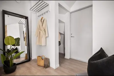 a living room with a mirror and a chair at Central 2 story modern apartment in Bergen