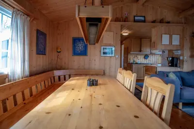 a dining room with a wooden table and a kitchen at Trysilfjellet Nord 637 in Trysil