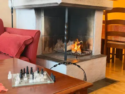 a fireplace in a living room with a table and a fire at Comfort, Sauna & Great Location! in Beitostøl