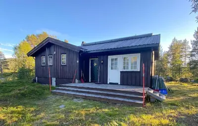 a small black house with a wooden porch at Amazing Home In Rauland in Rauland