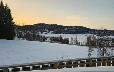 a snow covered field with a fence and mountains at 3 Bedroom Awesome Apartment In Rjukan in Rjukan
