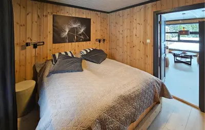 a bedroom with a bed in a room with wooden walls at 3 Bedroom Awesome Apartment In Rjukan in Rjukan