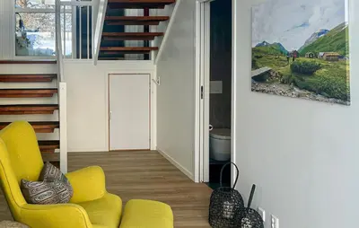 a living room with a yellow chair and stairs at Awesome Home In Oppdal With Sauna in Oppdal