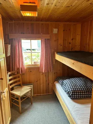 a bedroom with a bunk bed and a chair in a cabin at Convenient ski in-out on Norefjell in the alpine village in Surteberg