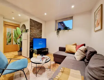 a living room with a couch and a tv at City center retreat with king bed in Bergen