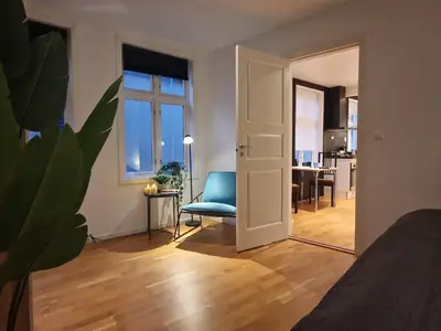 a living room with a blue chair and a table at City center retreat with king bed in Bergen
