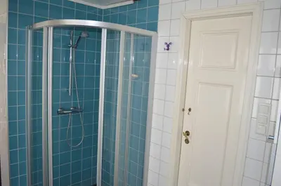a bathroom with a shower with blue tiles at Historic Bergen house, right in the middle of everything! in Bergen