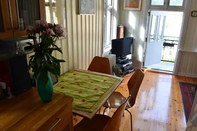 a dining room table with a vase of flowers on it at Historic Bergen house, right in the middle of everything! in Bergen