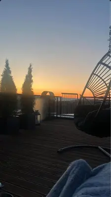a view of the sunset from a deck with a playground at Moderne hjem med høy standard og privat takterasse in Trondheim